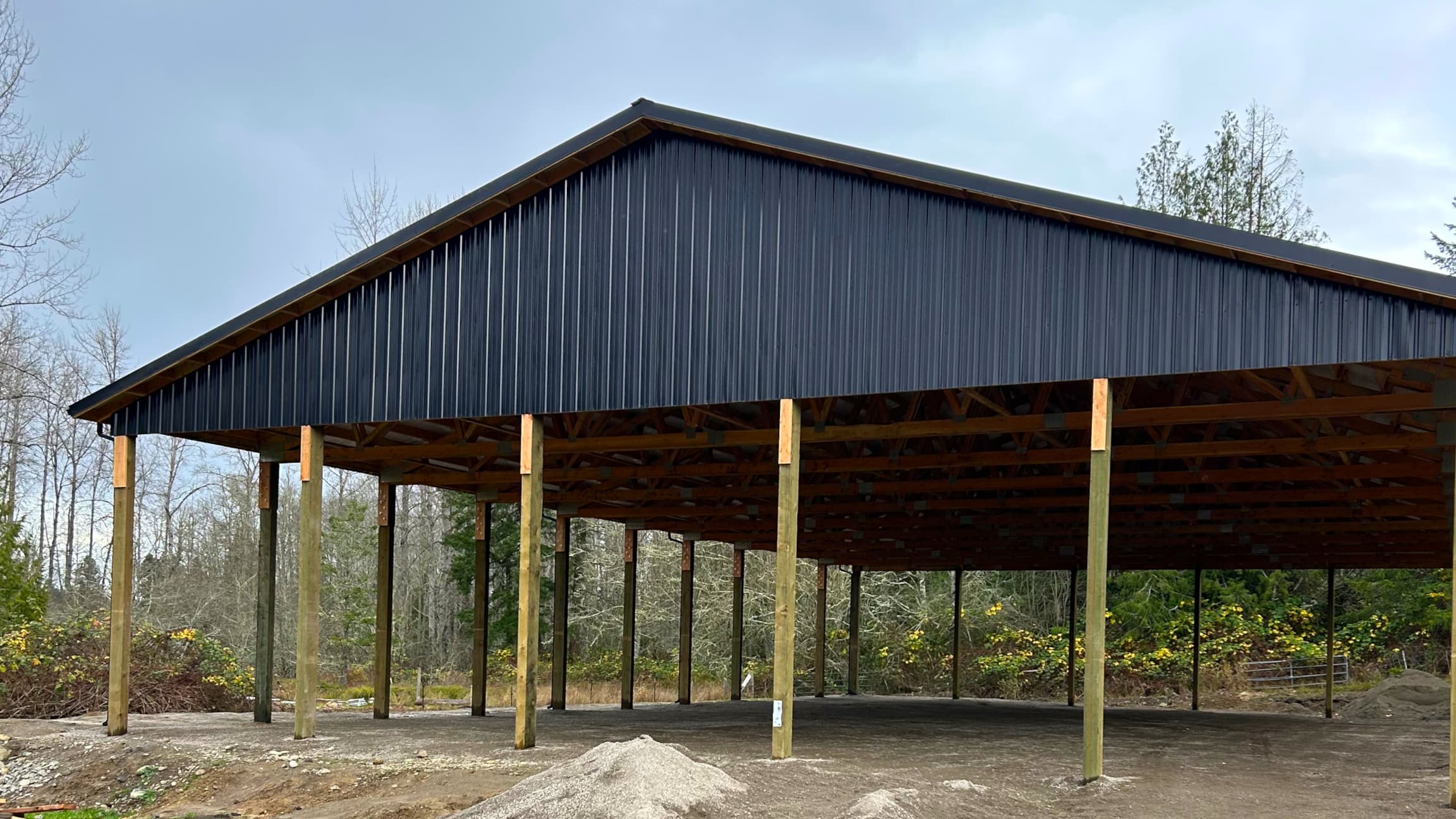 Front view of a custom-built 60x100 equestrian metal building in Puget Sound area. This 16-foot tall roof-only structure by Probuilt Metal Buildings provides ideal protection for year-round riding while withstanding Pacific Northwest weather conditions.
