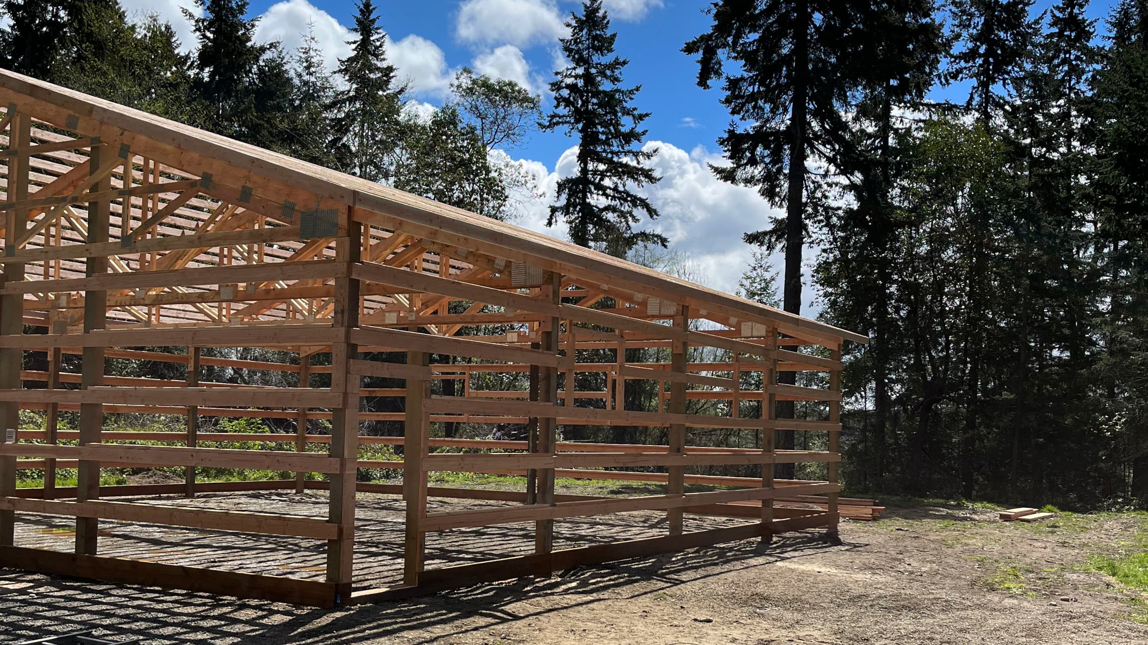 Angular view highlighting the walk-in door framing of this completed 40'x48' metal building framework by Probuilt in Port Orchard. This image captures the precision steel construction before the ash grey exterior panels and charcoal roof are installed. Shows the attention to detail that makes these 12-foot tall structures perfect for commercial and storage applications in the Pacific Northwest.